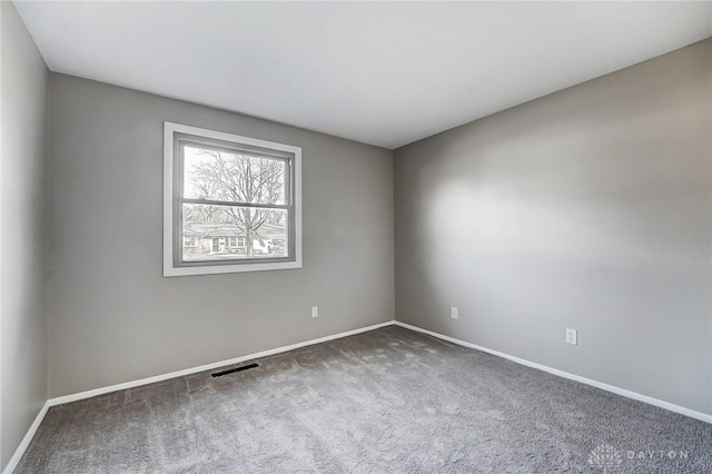 carpeted spare room featuring visible vents and baseboards