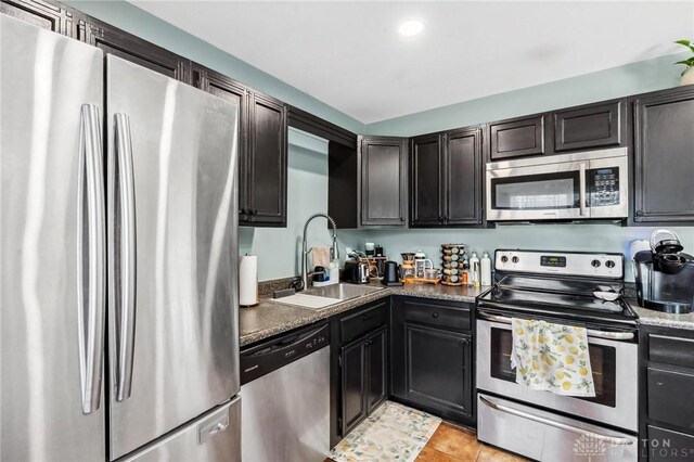 kitchen with a sink, stainless steel appliances, and light tile patterned floors