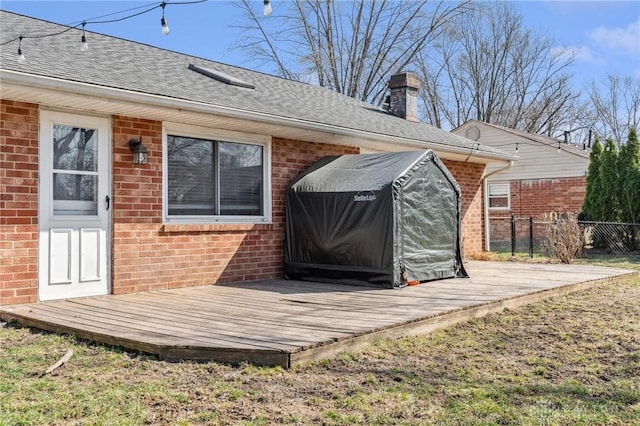 exterior space featuring brick siding, a chimney, and a deck