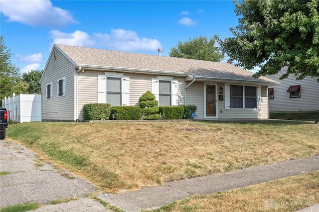 ranch-style house with a shingled roof and a front lawn