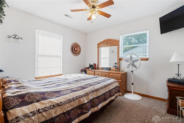 carpeted bedroom with visible vents, a ceiling fan, and baseboards