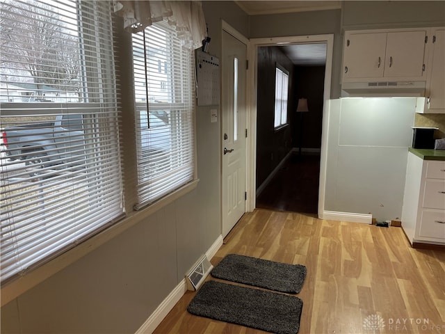 doorway to outside featuring baseboards, light wood-style flooring, and visible vents