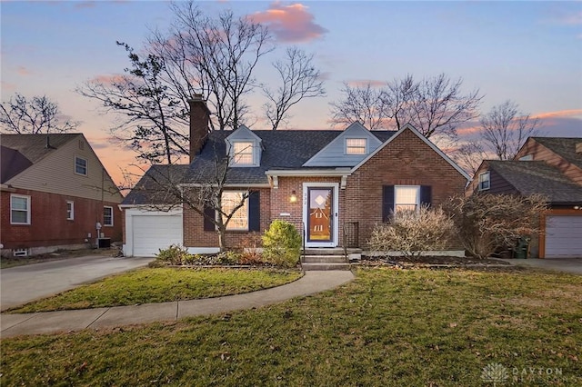 view of front of house with driveway, a yard, a garage, brick siding, and a chimney