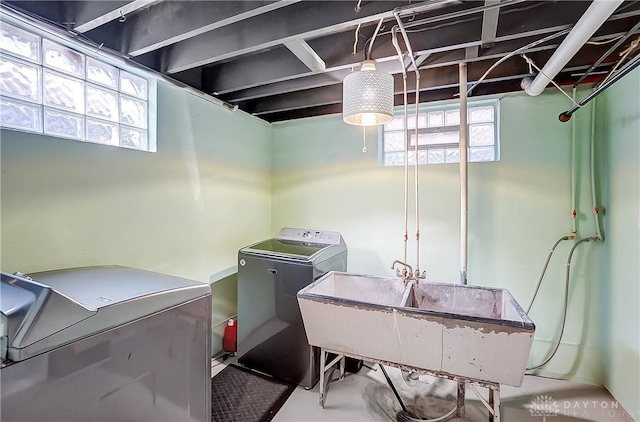 laundry room with laundry area, a sink, and separate washer and dryer