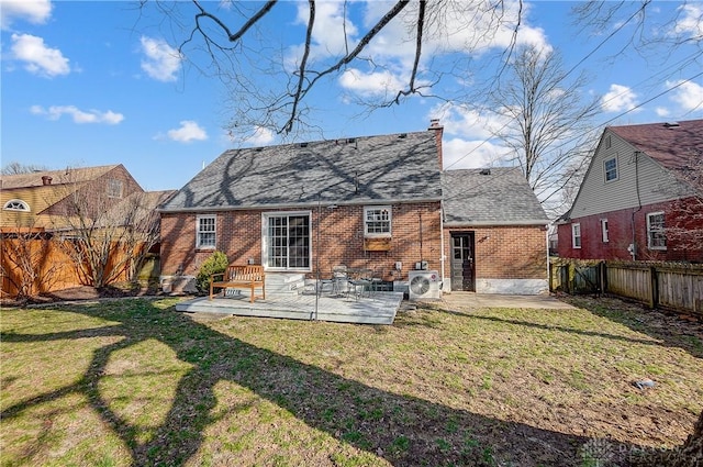 back of property featuring a patio, a fenced backyard, a chimney, a lawn, and brick siding