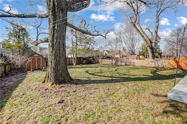 view of yard featuring a shed, an outdoor structure, and a fenced backyard