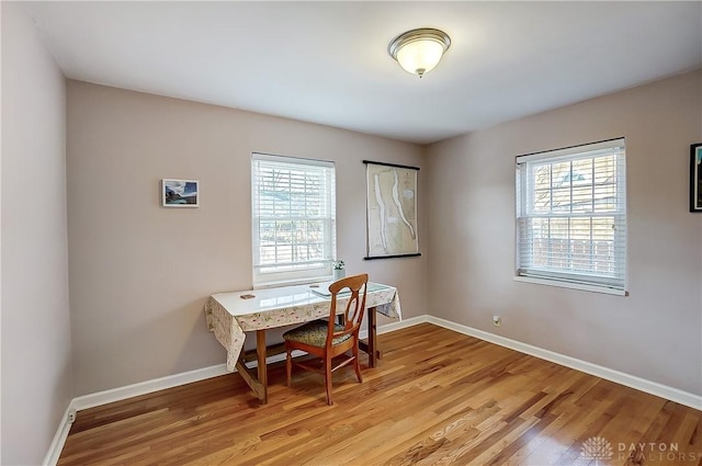 office area with baseboards, light wood-type flooring, and a wealth of natural light