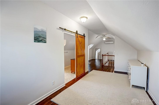 additional living space featuring ceiling fan, baseboards, dark wood finished floors, lofted ceiling, and a wall unit AC