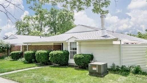 back of house with central AC unit, a yard, and fence