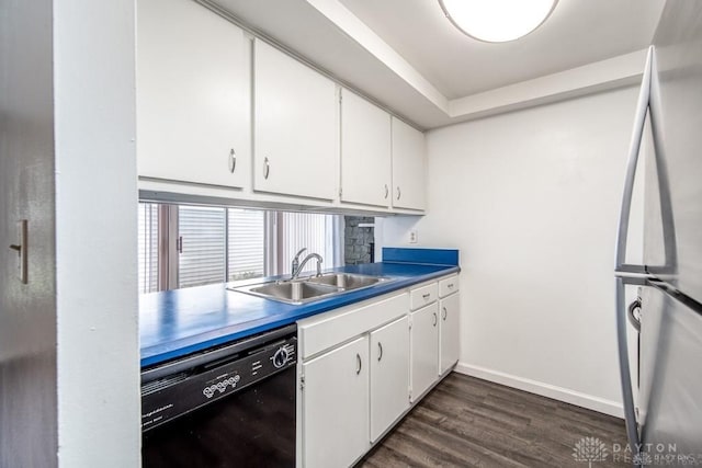 kitchen featuring dark wood-type flooring, dishwasher, freestanding refrigerator, white cabinetry, and a sink