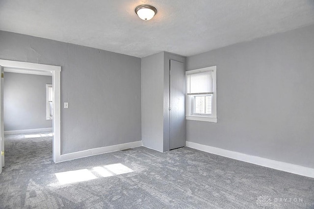 unfurnished bedroom with baseboards, carpet floors, and a textured ceiling