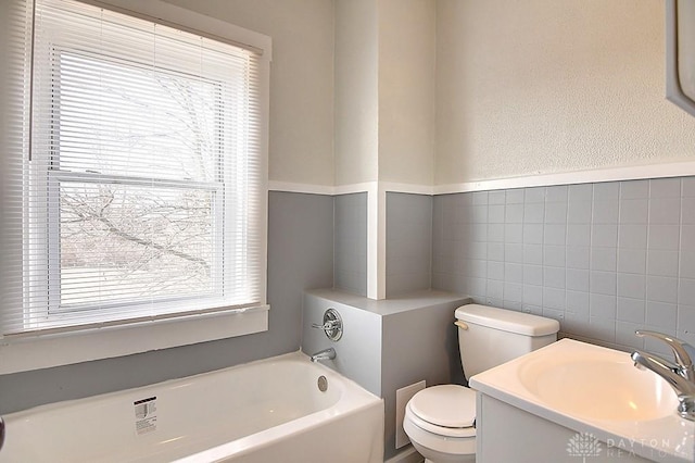 full bathroom featuring toilet, tile walls, a bath, and vanity