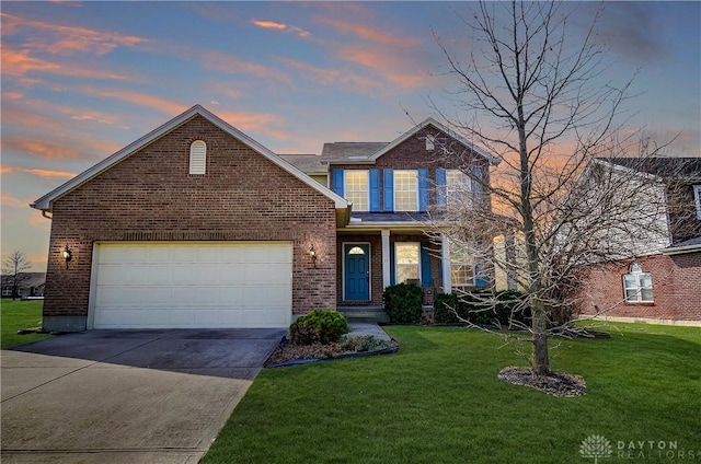 traditional-style home with brick siding, a front lawn, and driveway