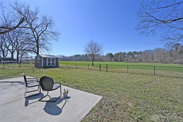 view of yard with a rural view, a fenced backyard, an outdoor structure, a storage unit, and a patio