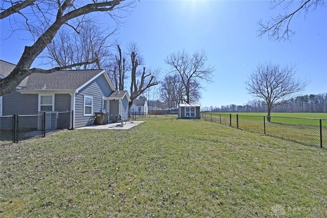 view of yard with an outbuilding, a storage shed, and a fenced backyard