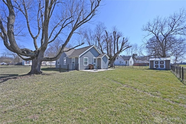 view of yard with an outbuilding, a fenced backyard, and a shed