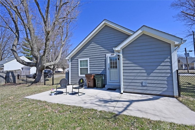 rear view of house with a patio area, a lawn, and fence