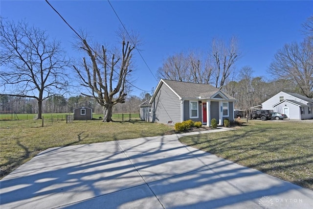 view of front of house featuring an outdoor structure, a front yard, and fence