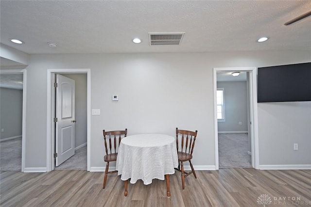 dining area with wood finished floors, baseboards, and visible vents