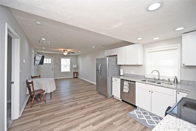 kitchen with visible vents, light wood-style flooring, appliances with stainless steel finishes, white cabinets, and a sink