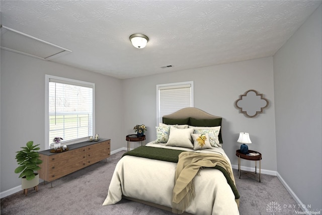 bedroom featuring visible vents, light carpet, and baseboards