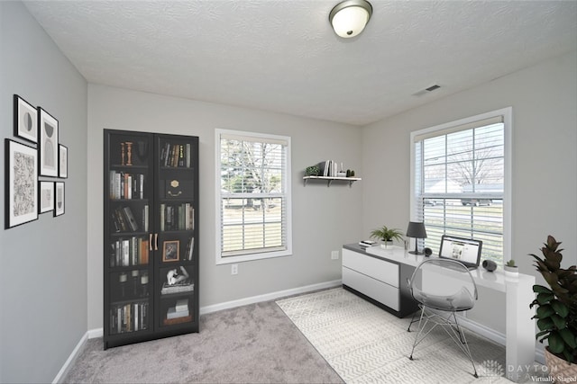 office with carpet flooring, baseboards, visible vents, and a textured ceiling