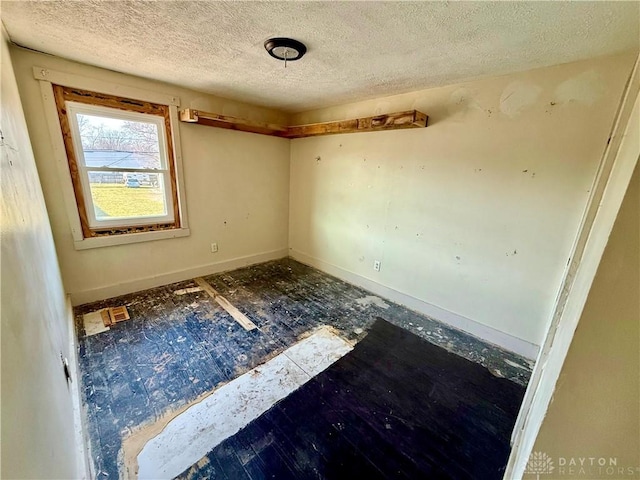 unfurnished room featuring a textured ceiling