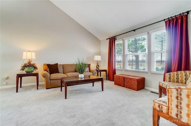 living area featuring high vaulted ceiling, baseboards, and light carpet