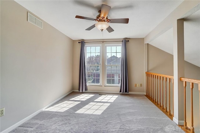 spare room with visible vents, baseboards, carpet flooring, and a ceiling fan