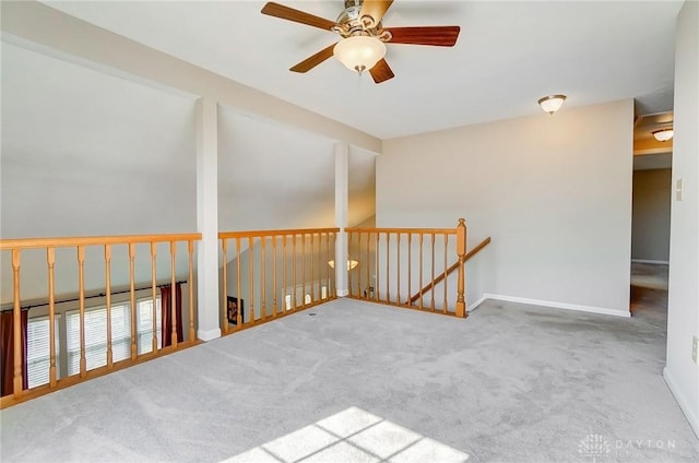 spare room with carpet flooring, a ceiling fan, and baseboards