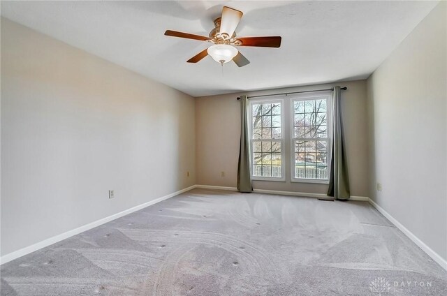 carpeted empty room with baseboards and ceiling fan