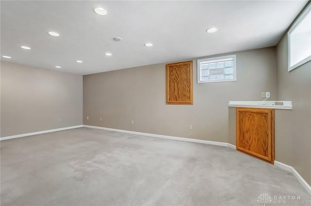 basement featuring light carpet, recessed lighting, and baseboards