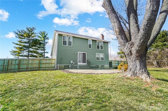 back of property with fence, entry steps, a lawn, a chimney, and a patio area