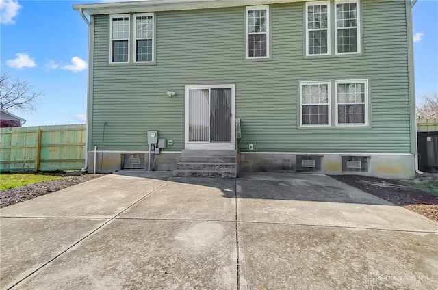 rear view of property featuring entry steps, a patio, and fence