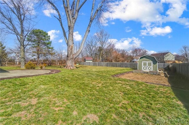 view of yard with a fenced backyard, an outdoor structure, and a shed