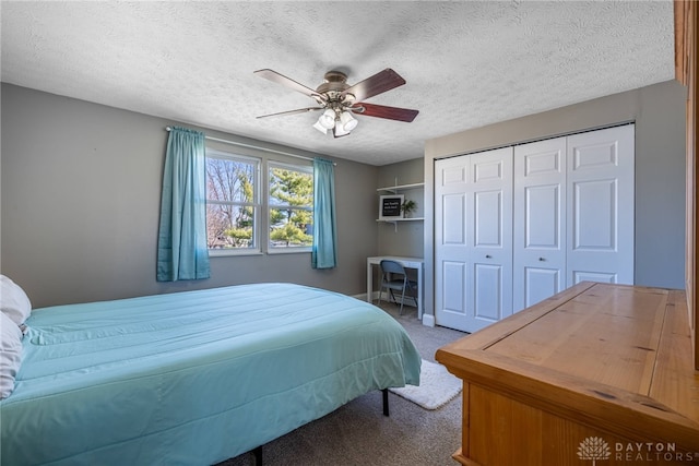 carpeted bedroom with a textured ceiling, a closet, and ceiling fan