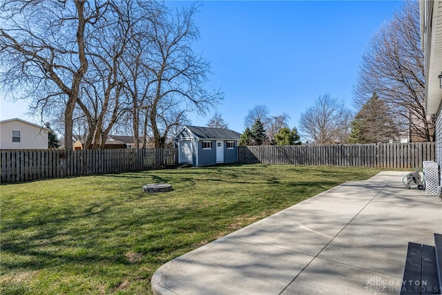 view of yard with a storage shed, an outdoor structure, a fenced backyard, and a patio