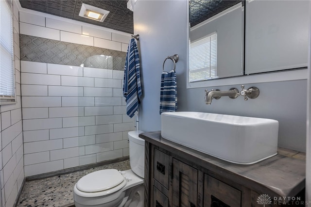 bathroom with tiled shower, toilet, and vanity