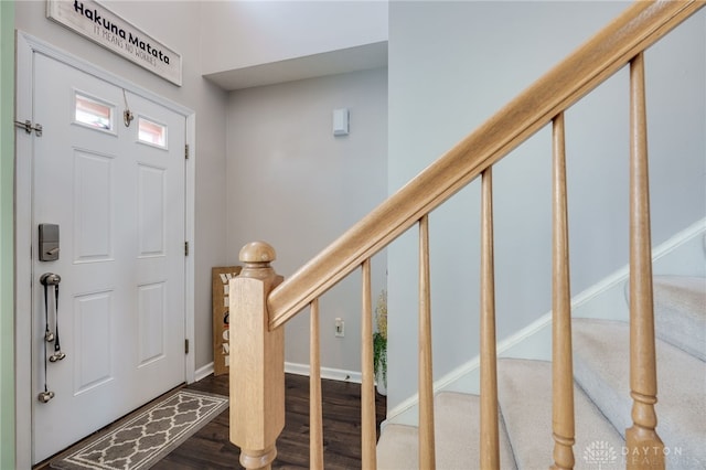 foyer entrance with baseboards, wood finished floors, and stairs