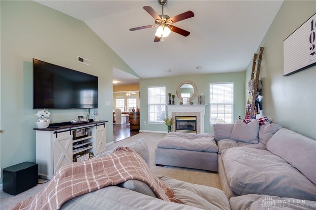 living area featuring visible vents, baseboards, ceiling fan, light colored carpet, and a tile fireplace