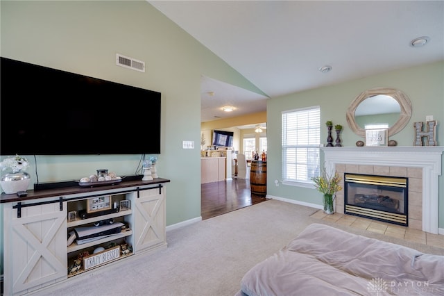 bedroom featuring visible vents, baseboards, light colored carpet, and a tiled fireplace