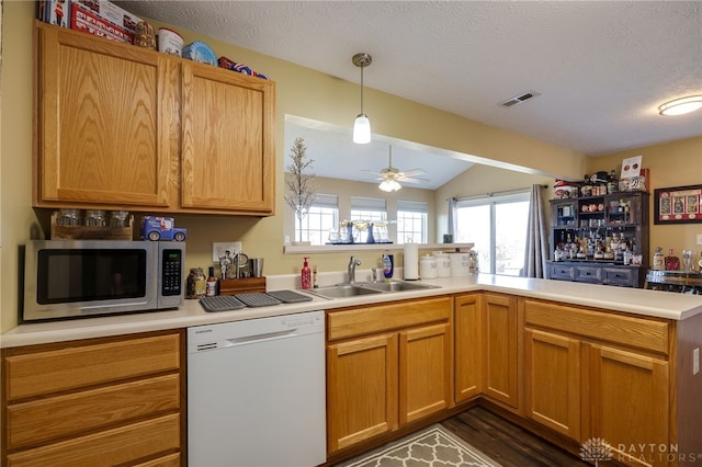 kitchen featuring white dishwasher, ceiling fan, a sink, light countertops, and stainless steel microwave