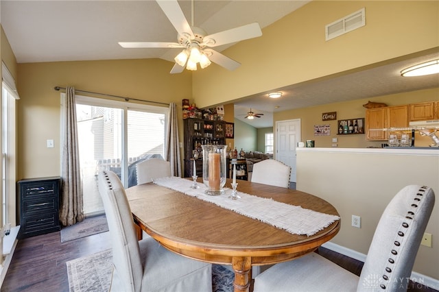 dining space featuring wood finished floors, baseboards, visible vents, ceiling fan, and vaulted ceiling