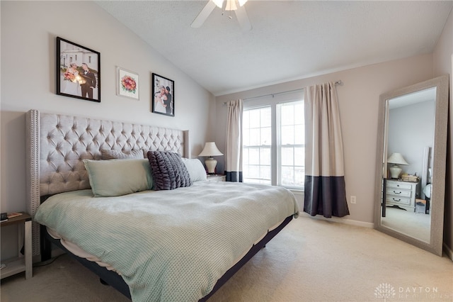 bedroom featuring lofted ceiling, a textured ceiling, baseboards, light colored carpet, and ceiling fan