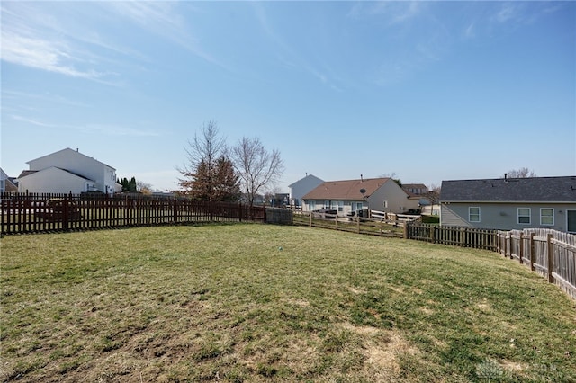 view of yard featuring a fenced backyard and a residential view