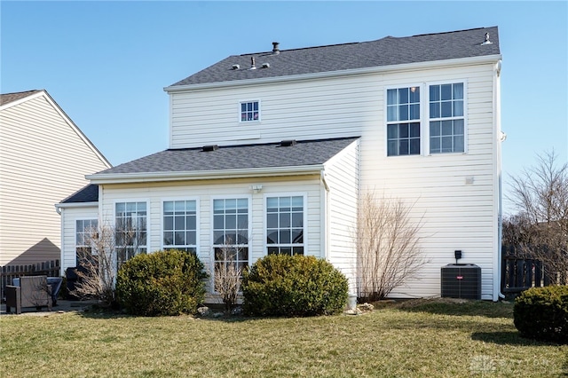 back of property featuring a lawn and roof with shingles