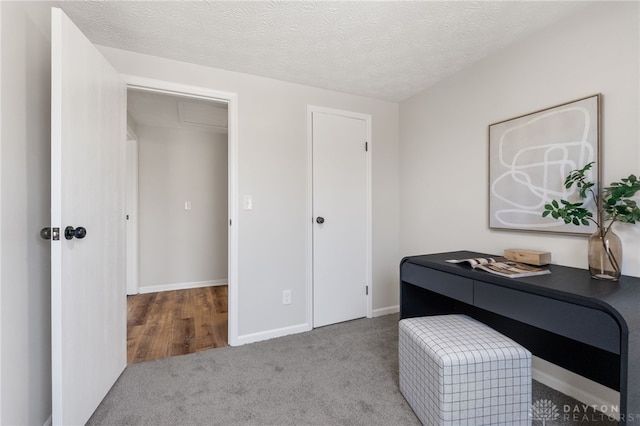 office space featuring carpet flooring, a textured ceiling, and baseboards