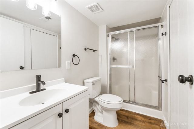 bathroom featuring vanity, wood finished floors, visible vents, and a stall shower