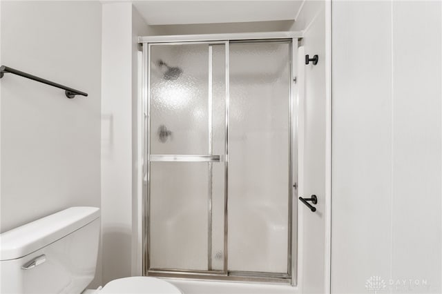 full bathroom featuring toilet and a shower stall