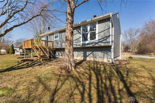 back of property featuring stairway, a yard, and a wooden deck